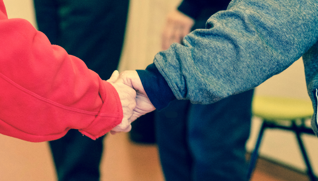 Photo of a carer hand in hand with loved on
